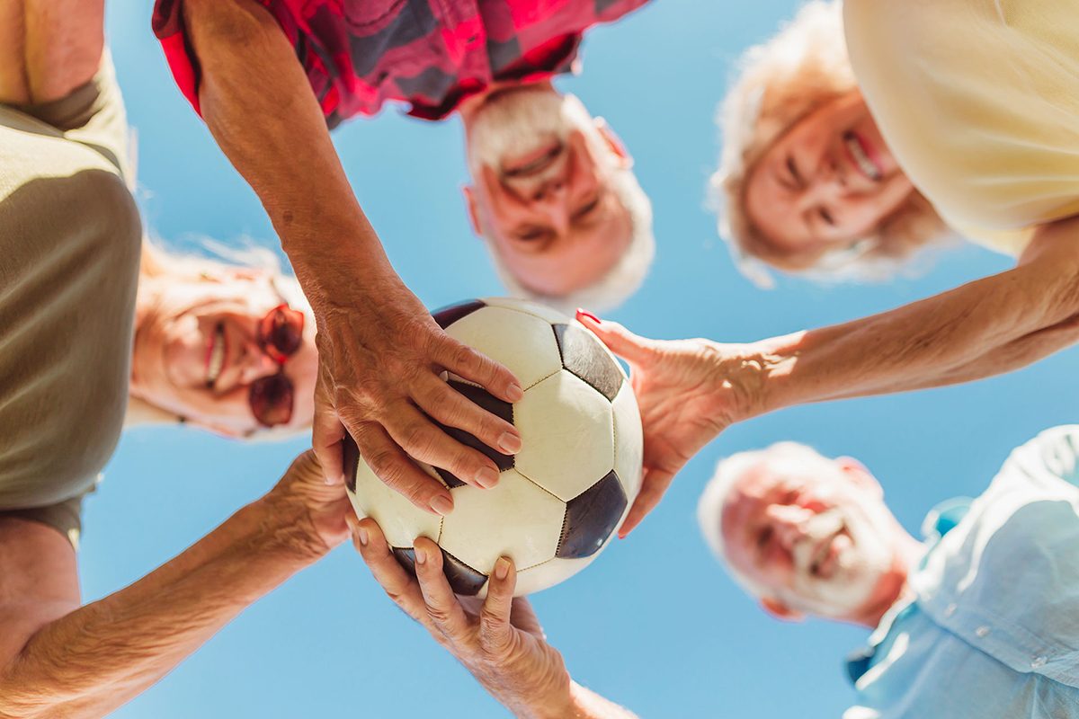 Senior people holding a soccer ball